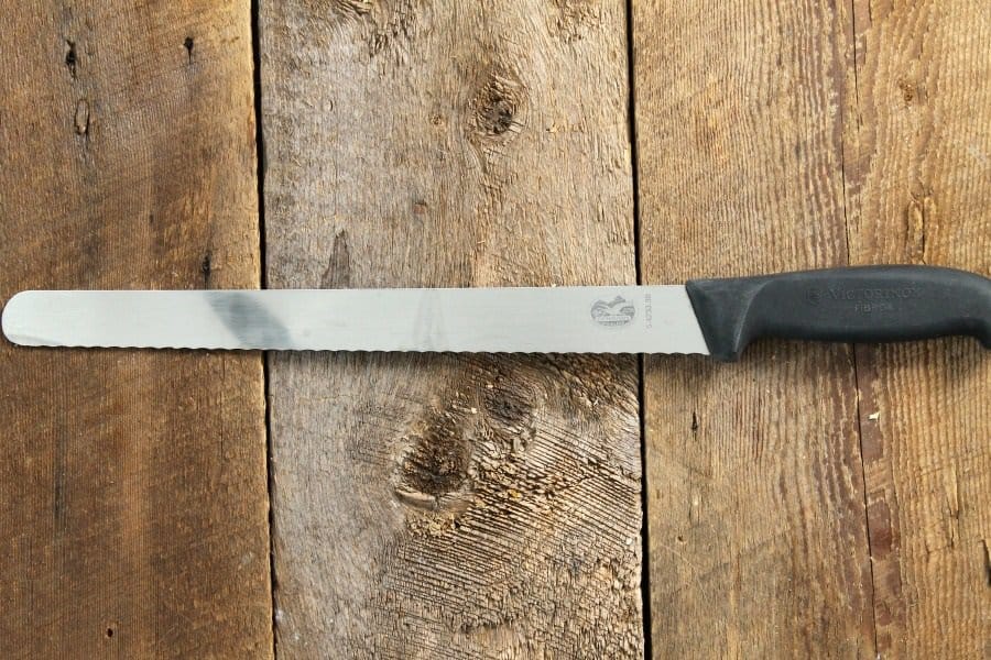 a victorianox 10" serrated slicer on a wood board tabletop