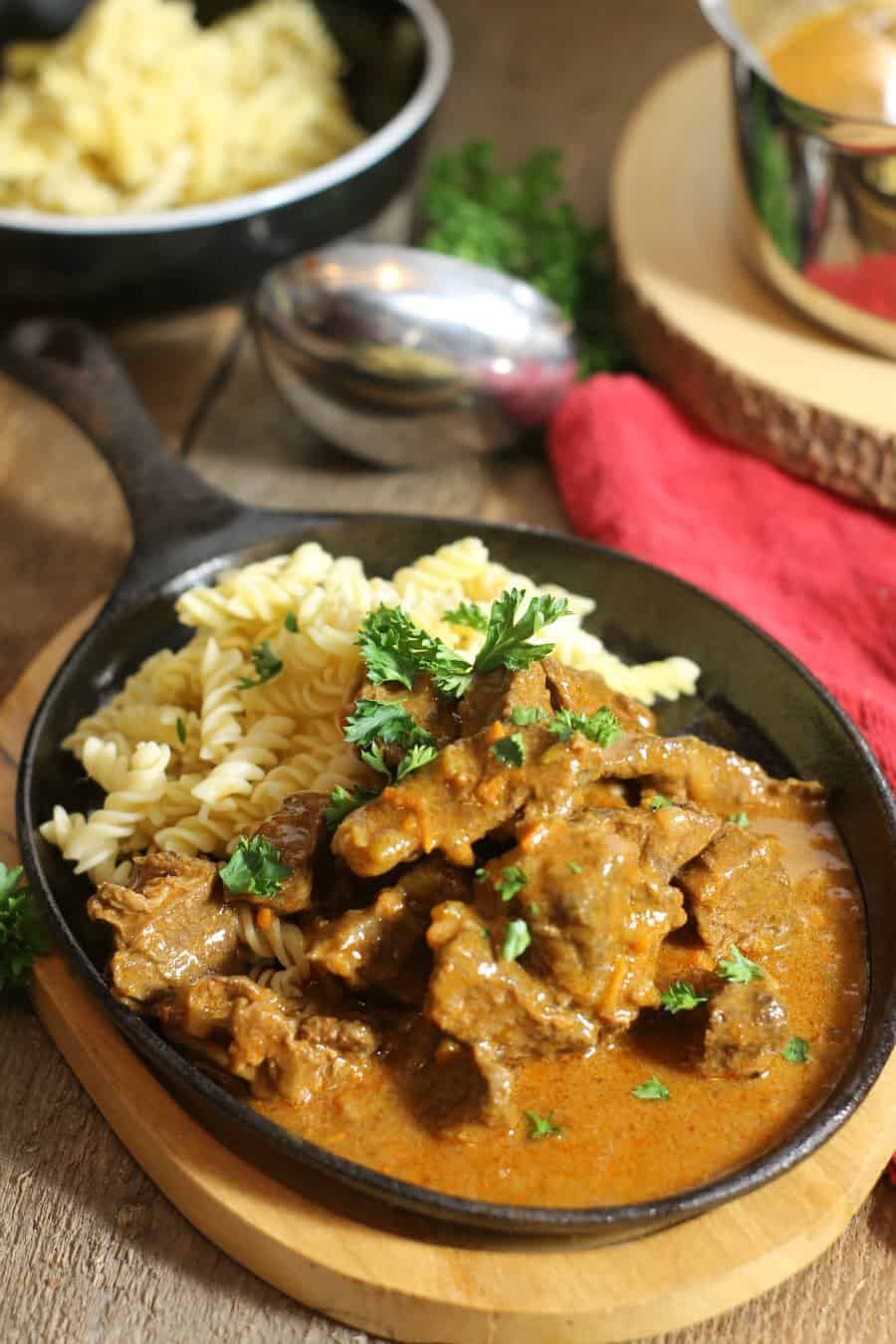 Ready to eat German goulash served with some fresh noodles and garnished with parsley