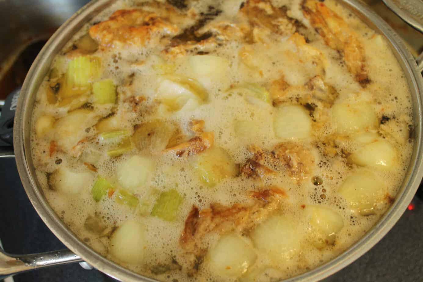 chicken stock simmering in a pot