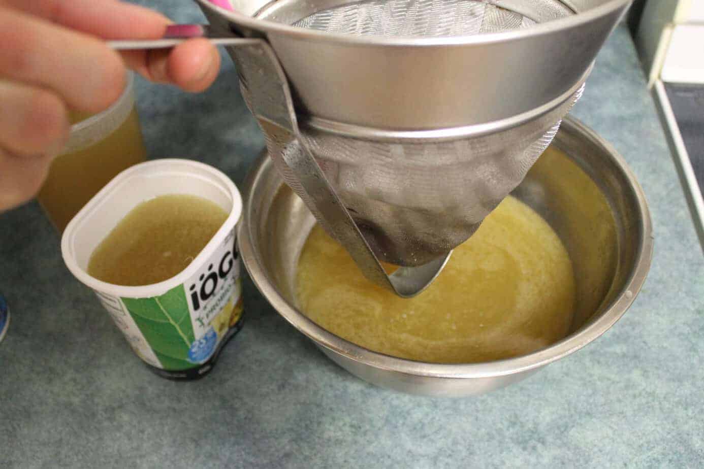 straining chicken stock through a chinois strainer