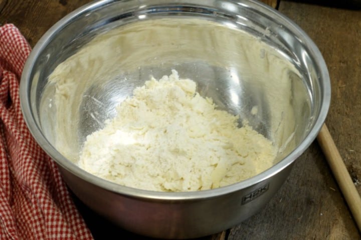 Flour and butter crumbled up in a stainless steel bowl for pie dough