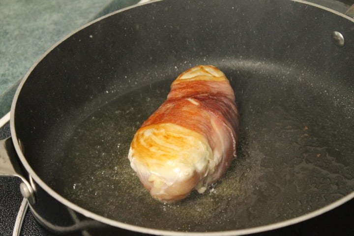 Basil Stuffed chicken searing in a pan