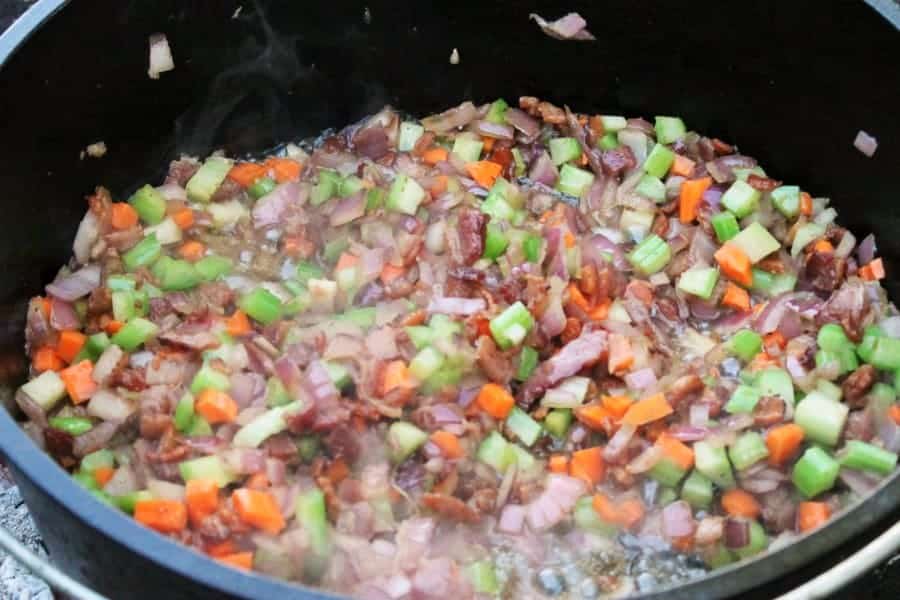 a cast iron pot filled with potato bacon corn chowder ingredients