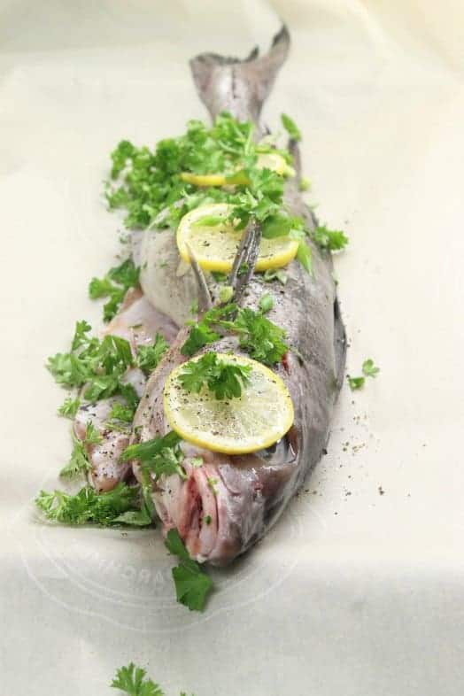 Prepping whole baked haddock for the oven.