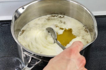 milk solids being skimmed off of butter as it is being clarified