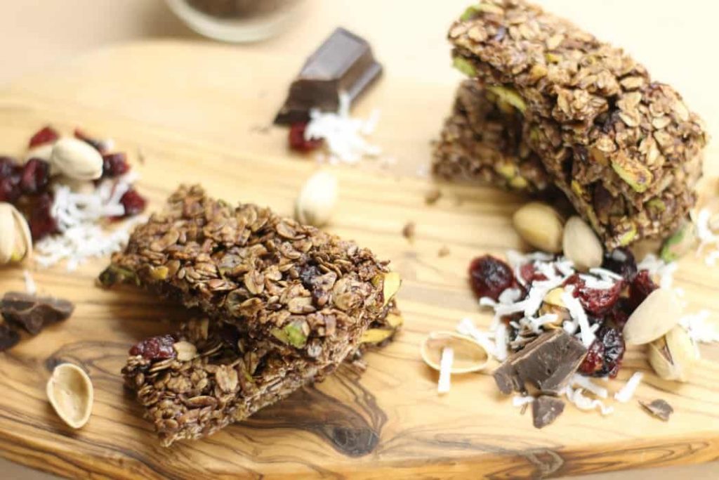 Pistachio, Cocoa, and Cherry stuffed homemade Granola Bars on a wooden board