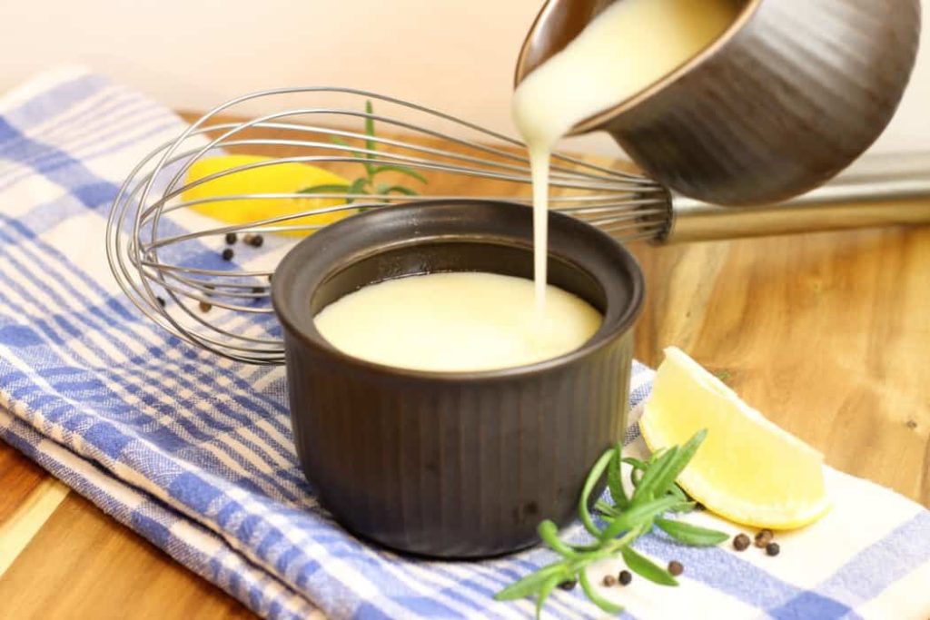 Veloute Sauce,( one of the five Mother Sauces), being poured into a brown ceramic dish.