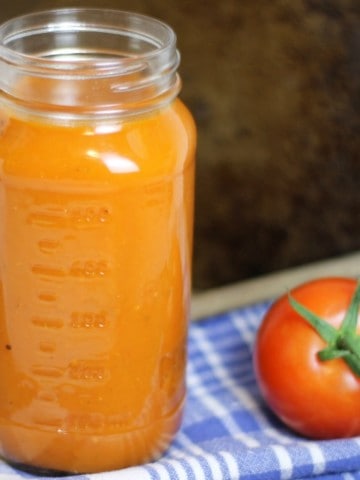 a mason jar filled with homemade tomato sauce, made from fresh tomatoes