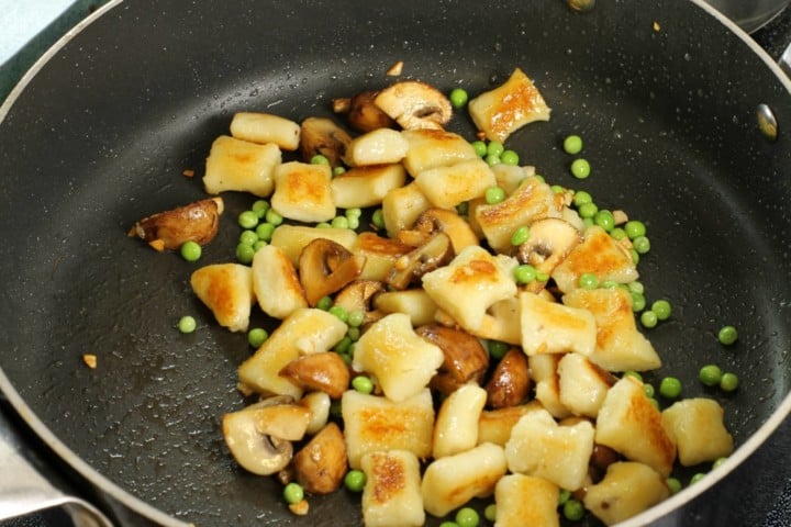 Homemade potato gnocchi pan fried and served with mushrroms and peas, a super tasty meal!