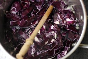 overhead shot of raw chopped red cabbage in a steel pot