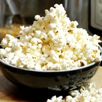 a black bowl of popped popcorn made in an instant pot.