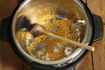 coconut oil and popcorn kernels in an instant pot, ready to be popped.