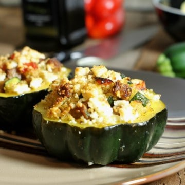 Two acorn squash stuffed with a quinoa and sauasage stuffing baked and topped with cheese