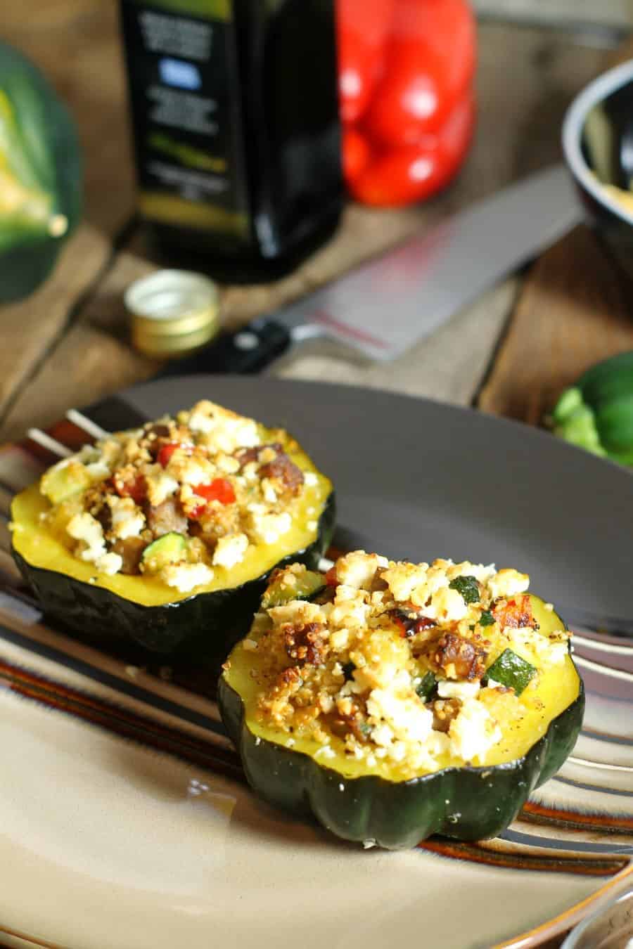 two baked acorn squash halves topped with feta, ready to be eaten.