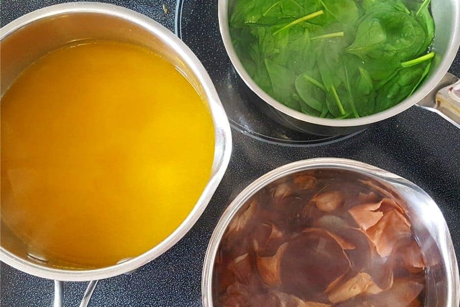 Three pots on the stove contaioning various natural dye ingredients