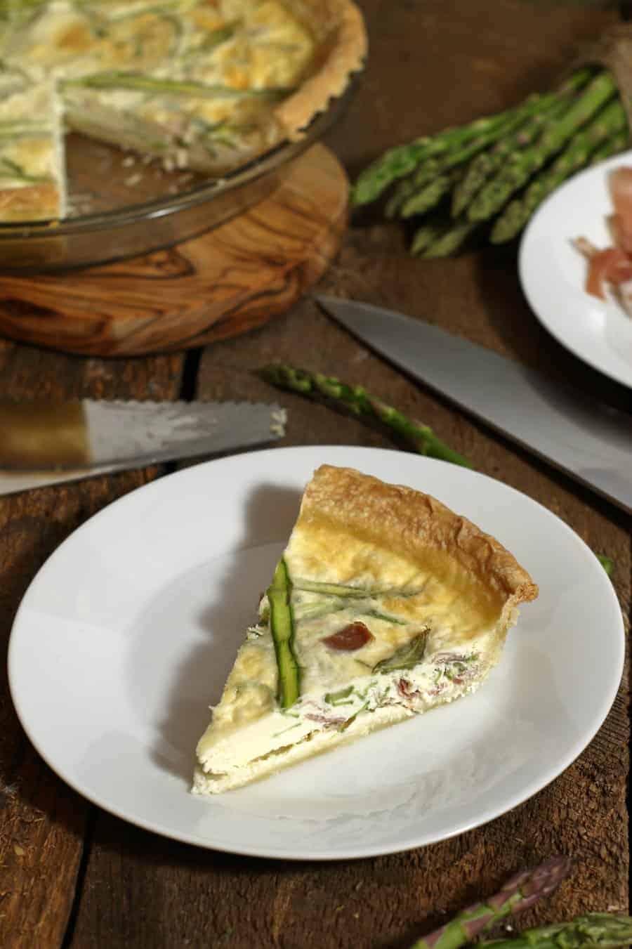 a top down view of a piece of prosciutto and asparagus egg white quiche