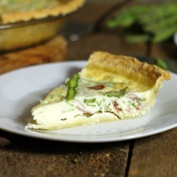 a slice of asparagus quiche on a white plate
