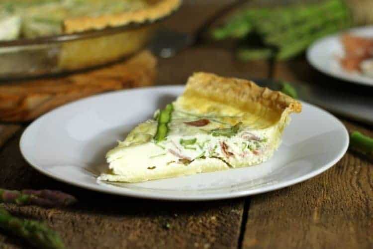 a slice of asparagus quiche on a white plate