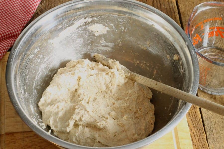 Mixing together the ingredients for this no knead sourdough bread in a metal bowl