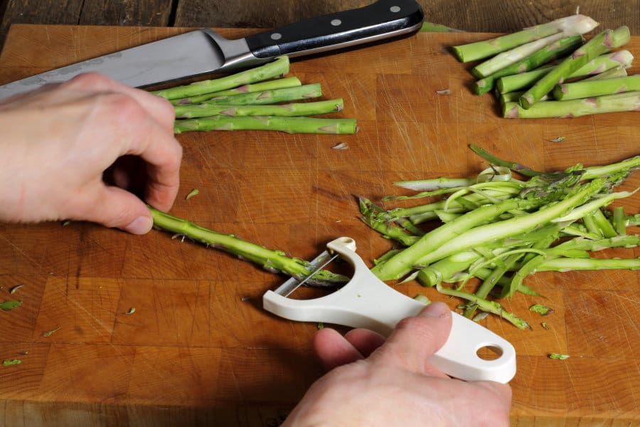 cutting asparagus spears into ribbons using a vegetable peeler