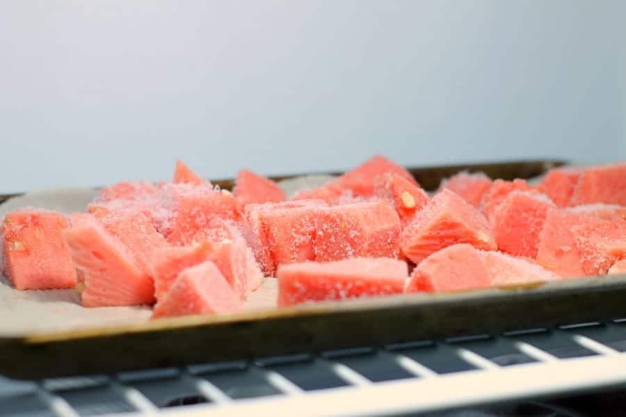 diced watermelon on a tray in the freezer