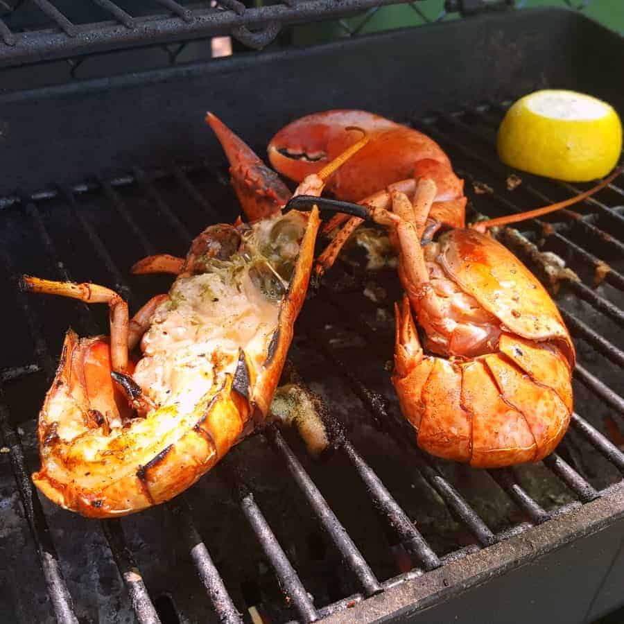 two blanched lobsters grilling on a BBQ