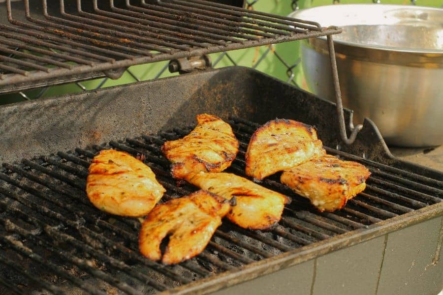 marinated chicken breasts grilling on a BBQ