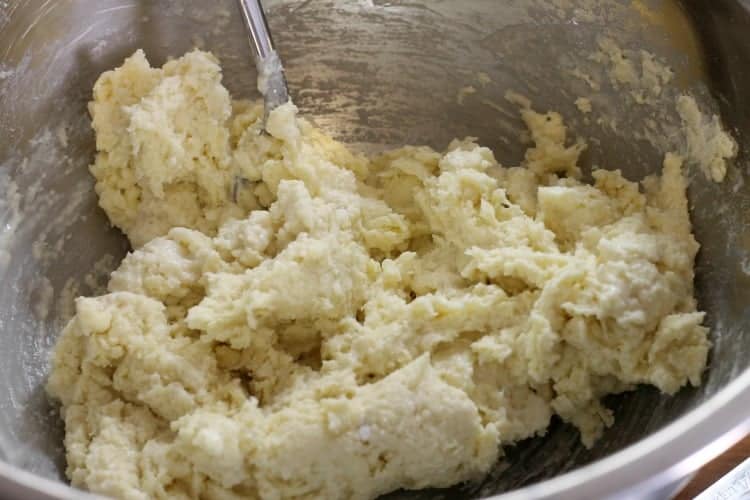 A biscuit like dough being mixed in a bowl. The dough will be used to top blueberry grunt