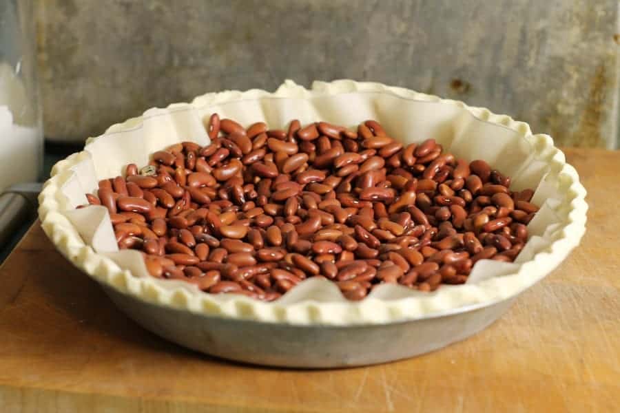 kidney beans being used as pie weights in a raw pie crust
