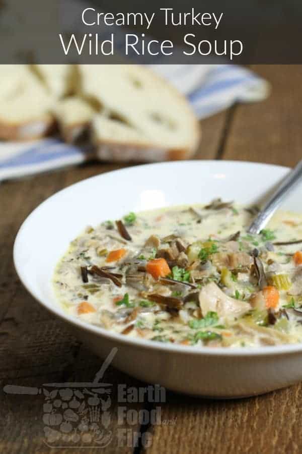 a close up of a white bowl filled with leftover turkey soup, a banner across the top reads reamy turkey wild rice soup