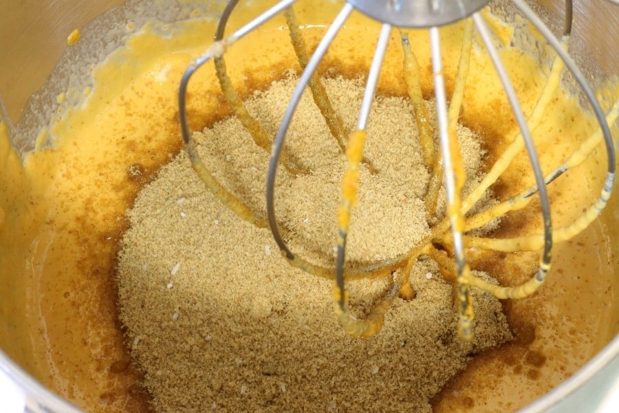 mixing the dry ingredients into the wet ingredients when making pumpkin pie filling