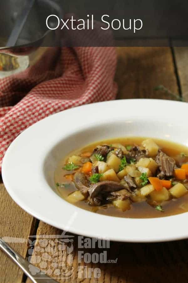 a vertical image of oxtail soup in a white rimmed bowl with a banner reading 'oxtail soup' across the tol