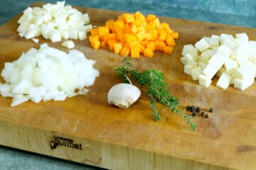diced onion, carrot, parsnip, and celery root on a cutting board