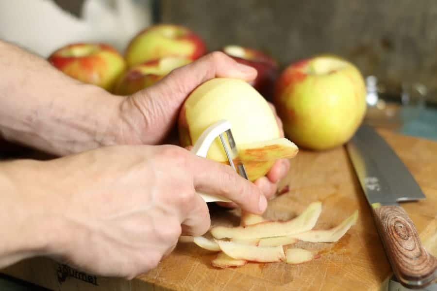 honeycrisp apples being peeled with a white hand held peeler