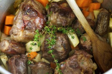 roasted oxtail bones,in a pot with diced vegetables and herbs