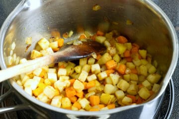 diced root vegetables sauteeing in a pot with butter
