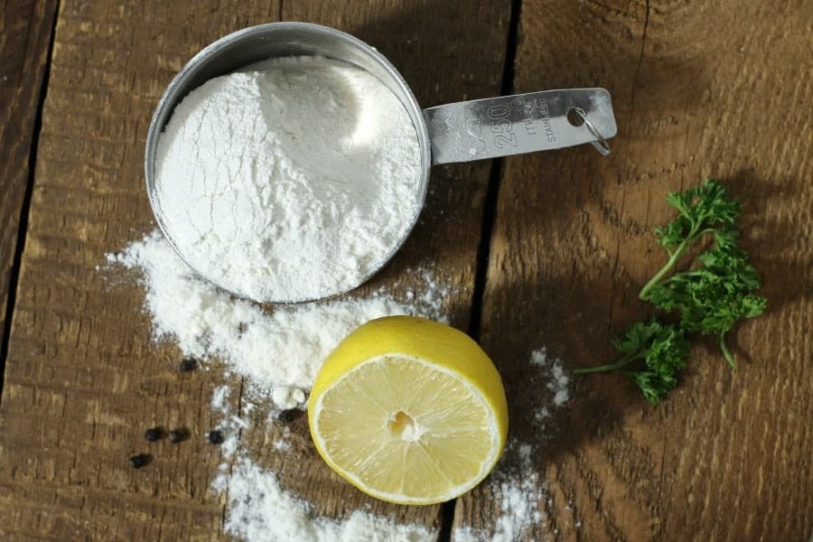 all purpose flour in a measuring cup on a wooden surface