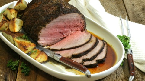 a sliced coffee rubbed sirloin tip roast on a white platter