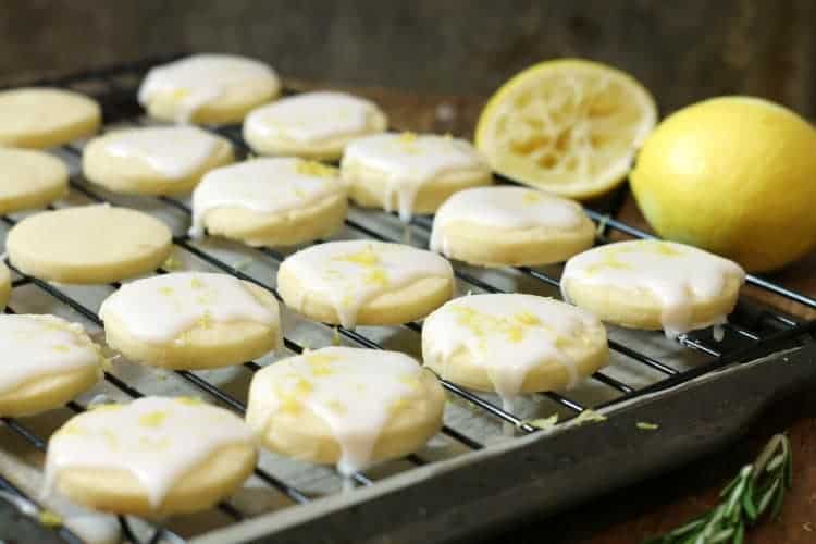 Glazed lemon shortbread cookies on a black cooling rack