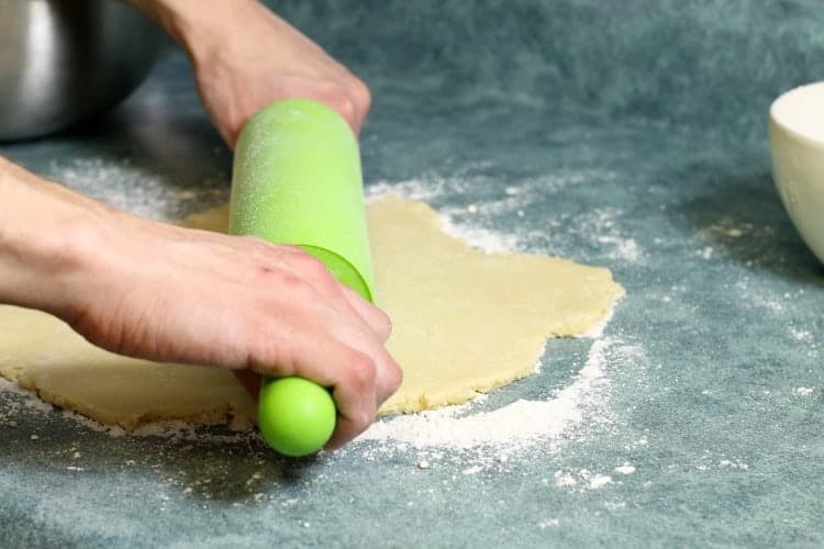rolling out shortbread dough on a lightly floured counter