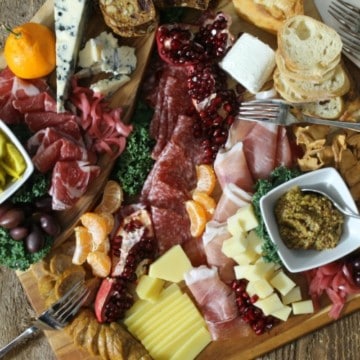 A rustic, holiday themed charcuterie platter on a wood board surface