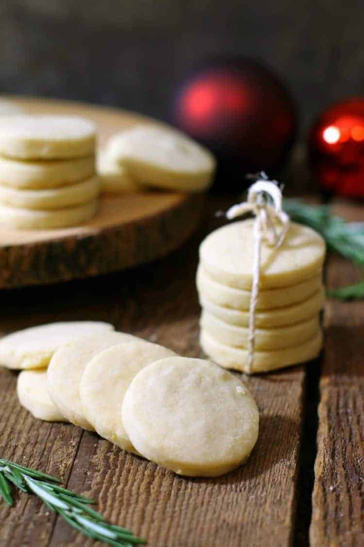 vertical image of traditional shortbread cookies stacked on a wooden surface