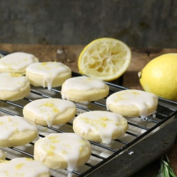 Glazed lemon shortbread cookies on a black cooling rack