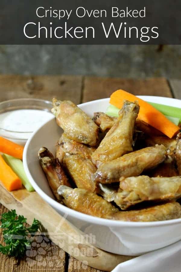 oven baked chicen wings in a white bowl with carrot and celery stick garnishes