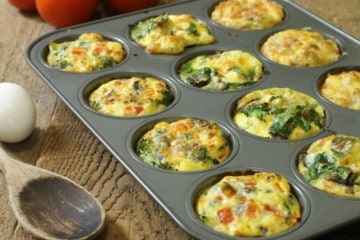 Three different kinds of breakfast egg muffins in a twelve cup muffin tin