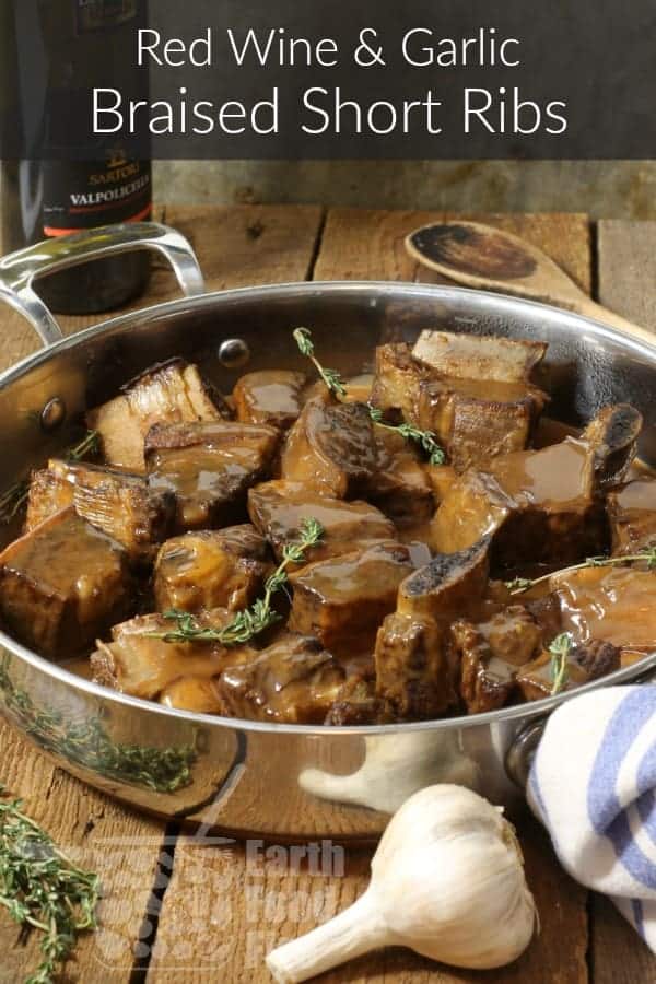 Red wine braised short ribs in a frying pan covered with rich gravy.