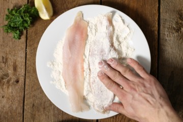 coating haddock with a flour and spice mixture prior to pan frying