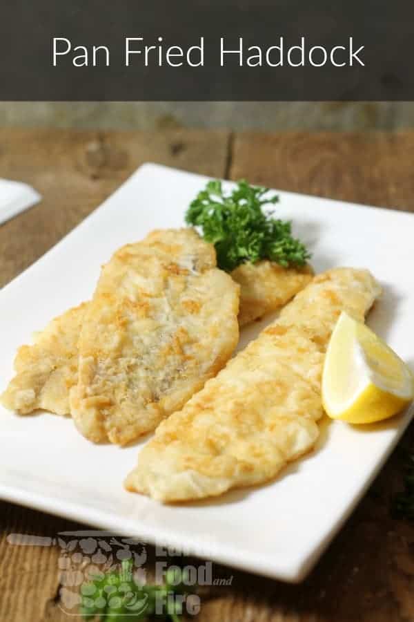 pimnterest image of pan fried haddock on a white square plate garnished with lemon and parsley