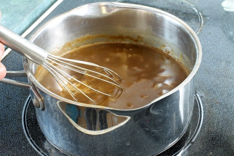 red wine sauce being thickened in a pot on the stove top