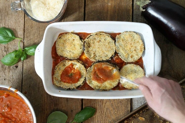 topping the eggplant slices with more tomato sauce